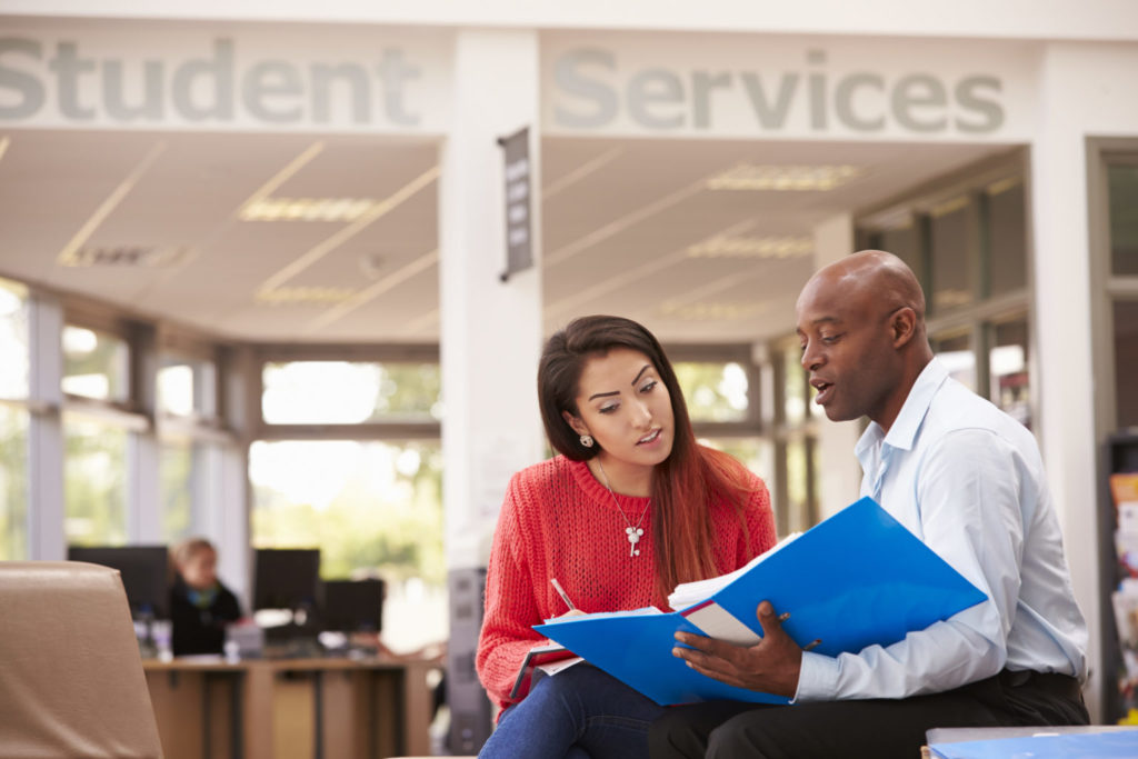 An advisor helping a student in a community or technical college student services office